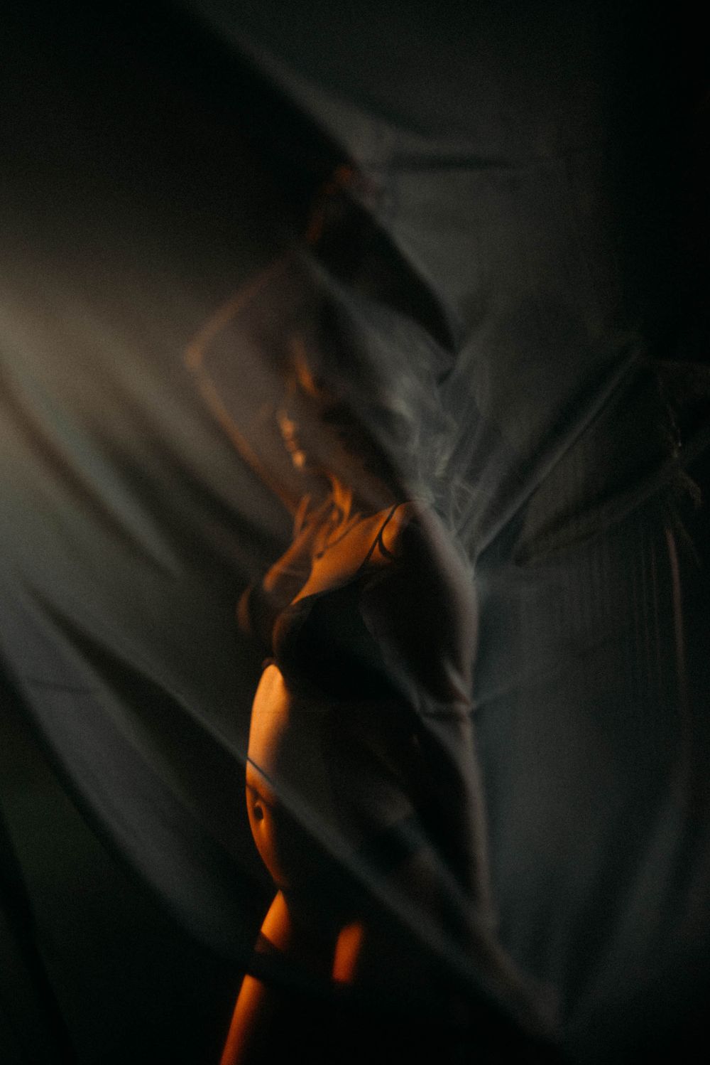 Moody photography series with orange lighting and fabric creating abstract shapes.