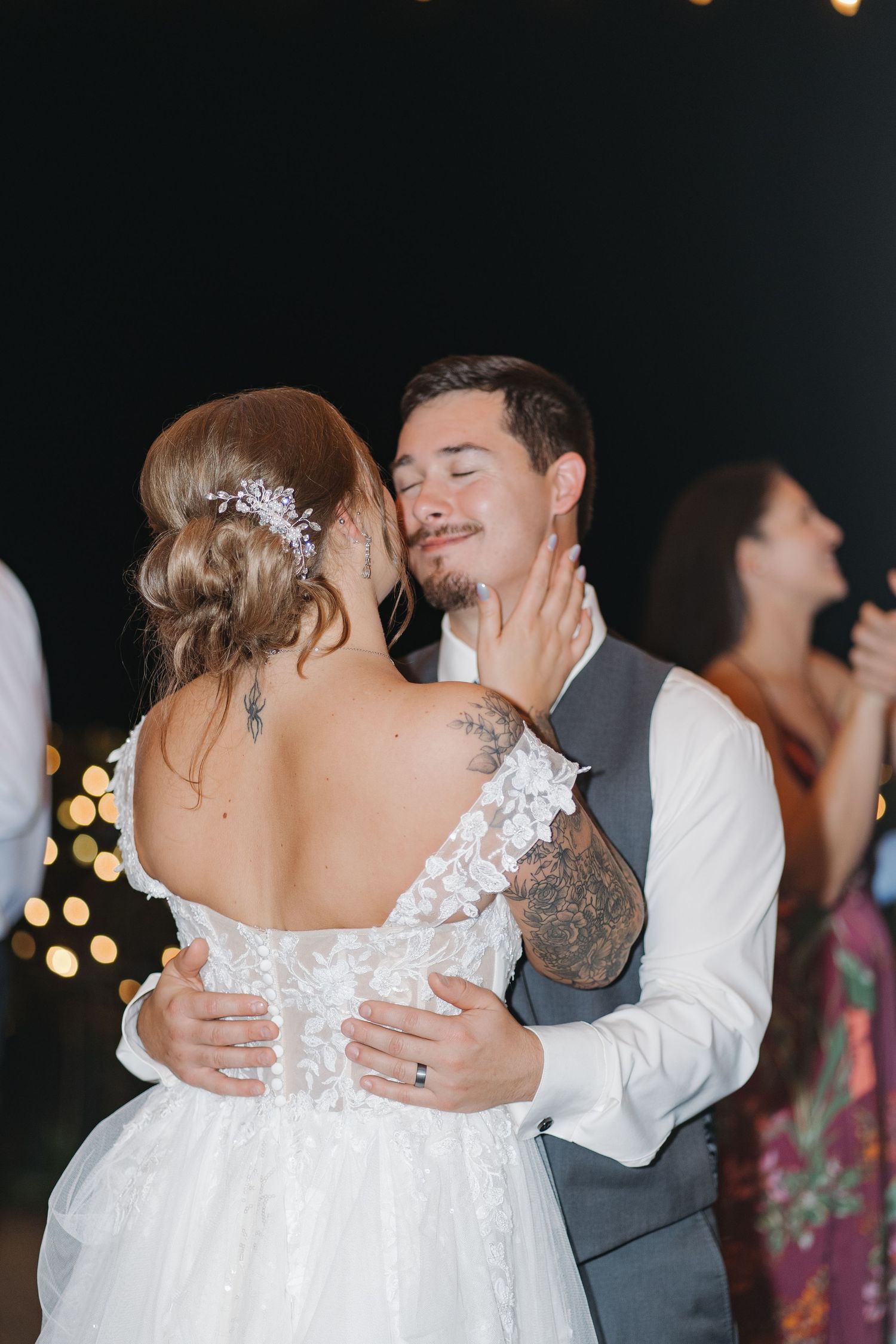 Newlywed couple shares an intimate moment while slow dancing at their wedding reception.