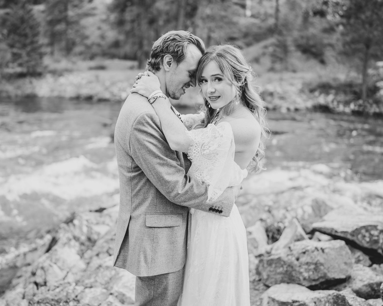 Black and white intimate portrait of newlyweds embracing in a mountain setting.