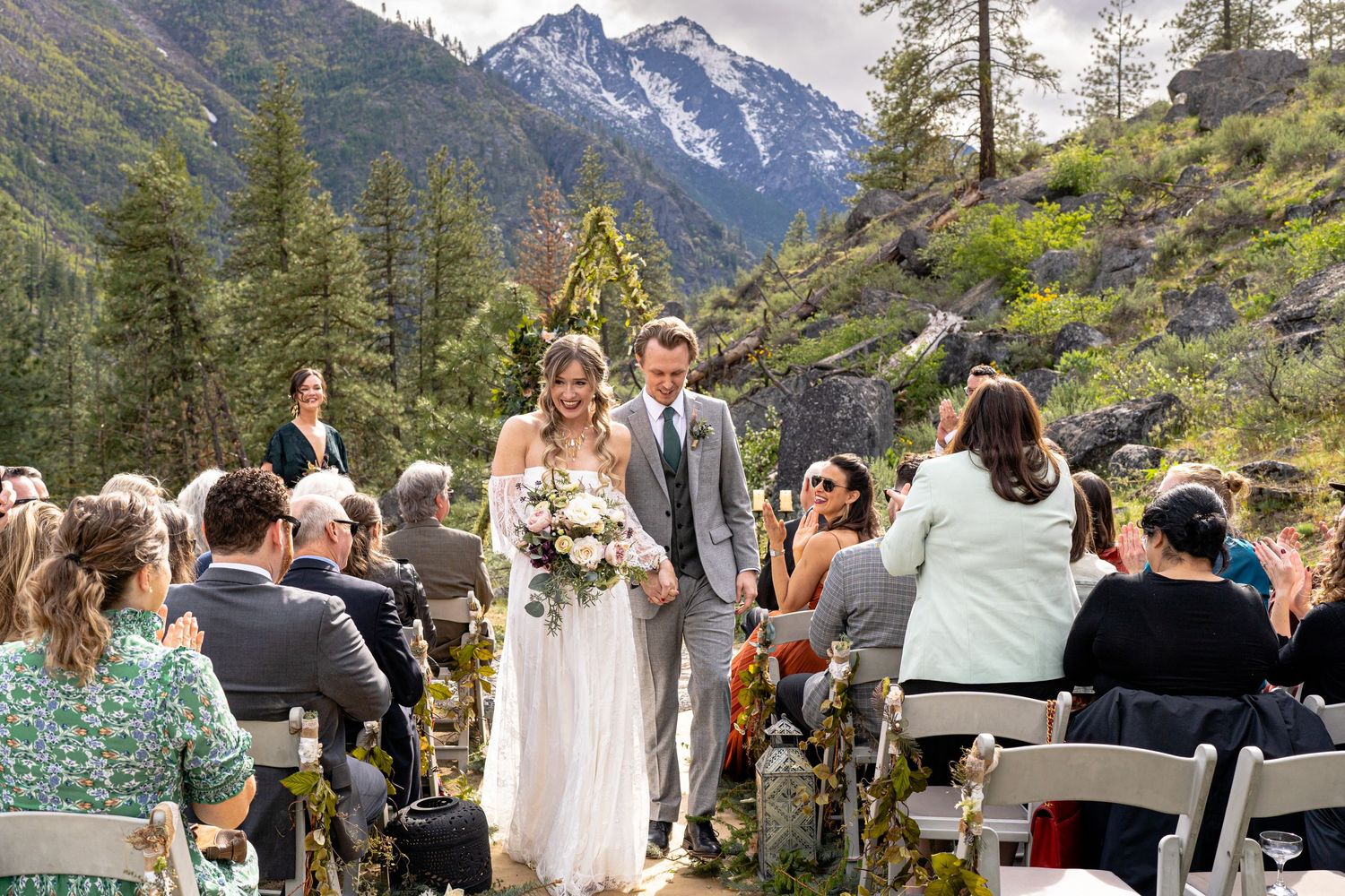 Mountain wedding ceremony with snow-capped peaks and evergreen trees creating a majestic backdrop.