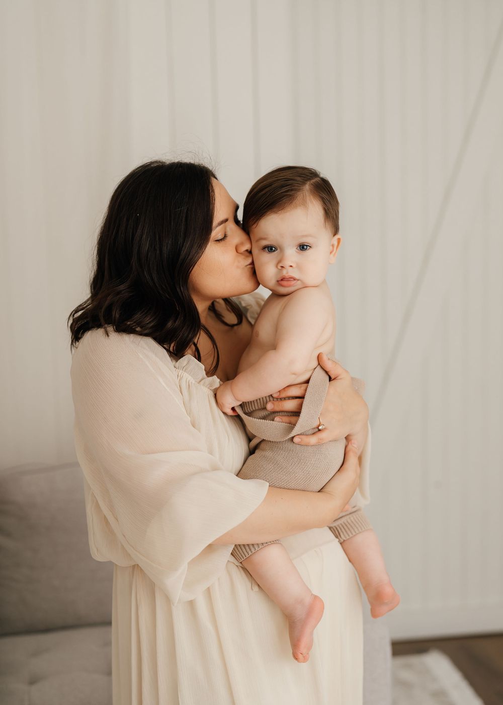 Tender moment between parent and child in soft neutral tones.