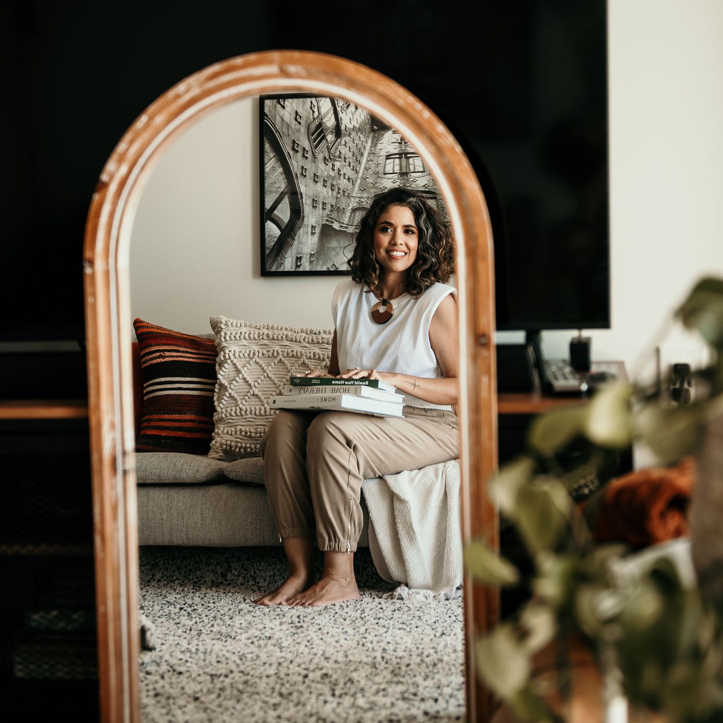 Mirror reflection showing a cozy living room scene with a comfortable sofa and decorative pillows.