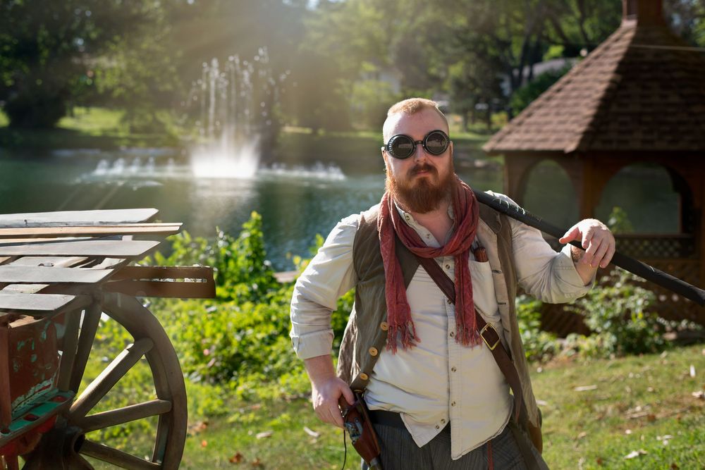 Adventurers gather near a lakeside pavilion during a fantasy roleplay event.