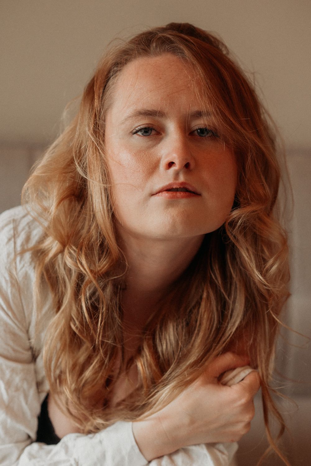 Series of artistic portraits showing flowing strawberry blonde hair in motion against a neutral background.