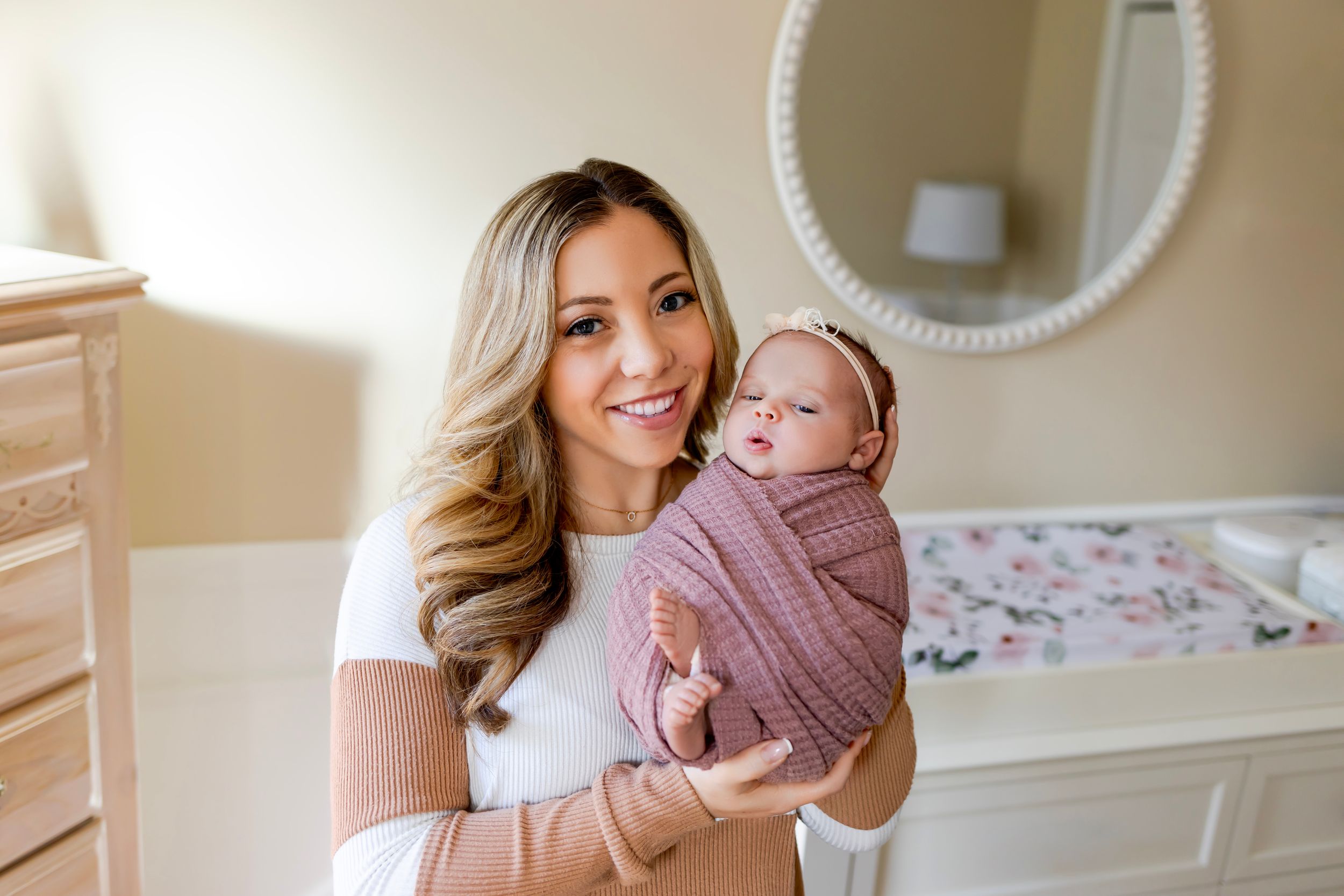 Mom holds a newborn baby wrapped in a mauve swaddle blanket. NJ Newborn Photographer in home session