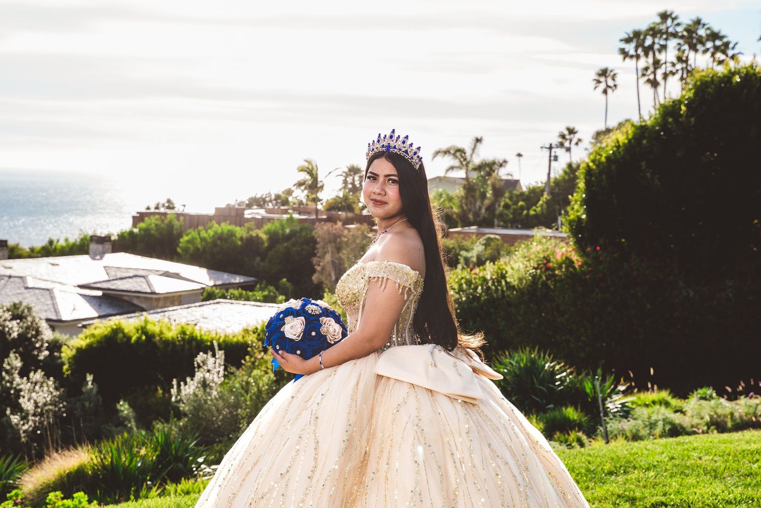 An elegant ballroom portrait featuring a champagne-colored lace ball gown and tiara.