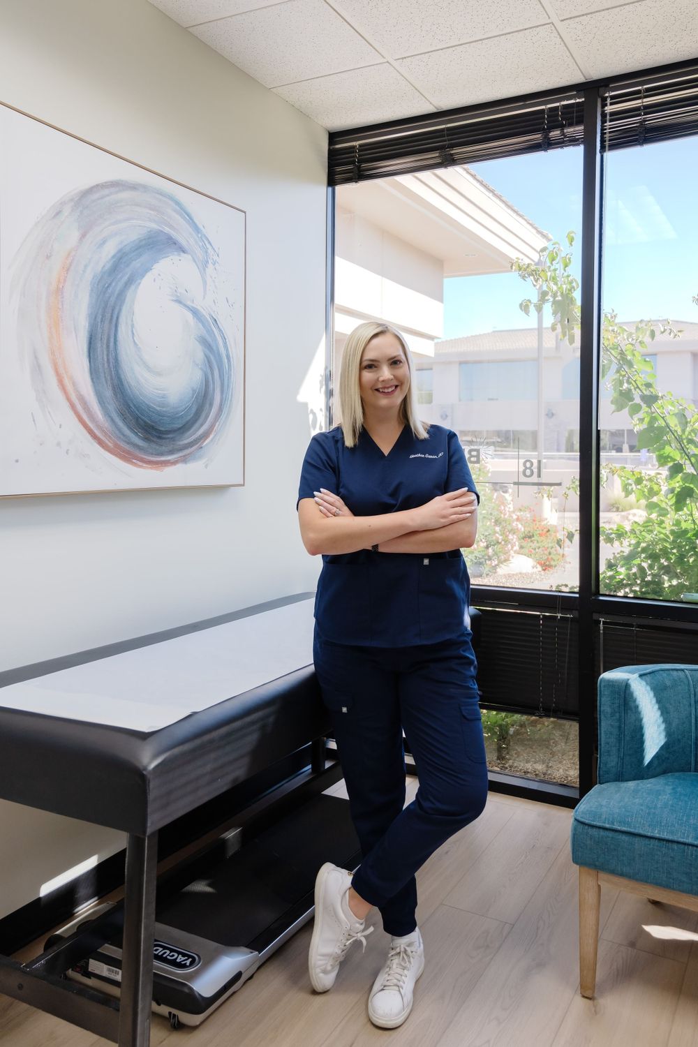 Medical office interior with abstract wave artwork and large window offering natural light.