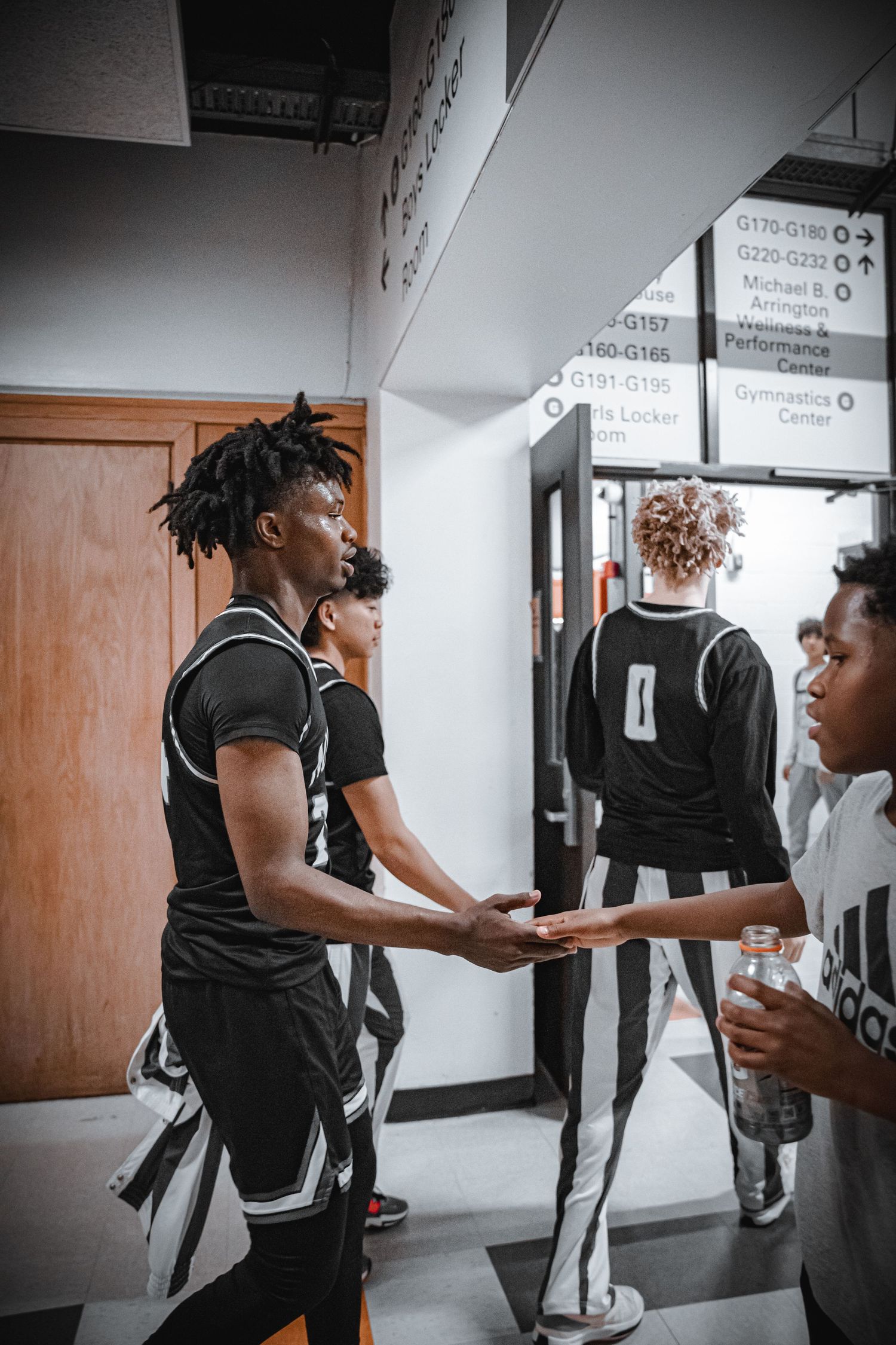 Athletes interact in a hallway before or after a game.