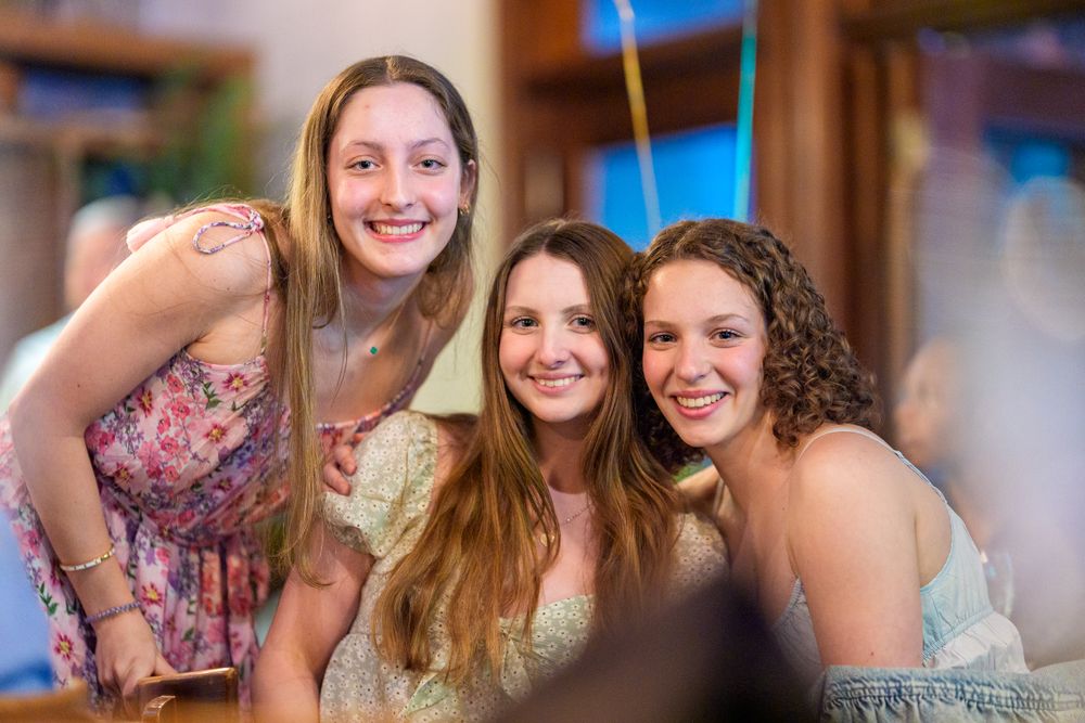 Three friends celebrating at party with festive decorations.