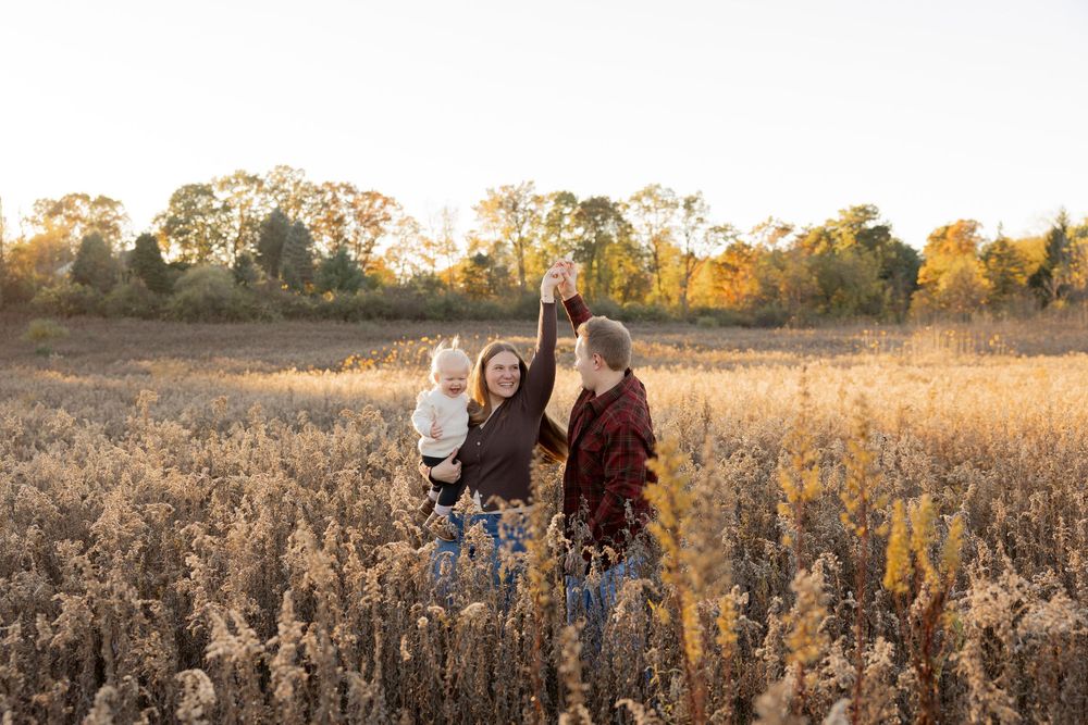 outdoor family portraits captured in a golden sunlit field during sunset at fox nature preserve in lake Orion, Oakland township, Rochester
