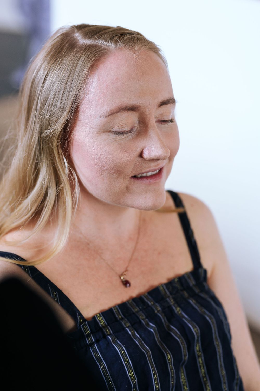 A candid portrait showing contentment and natural expression in soft lighting.