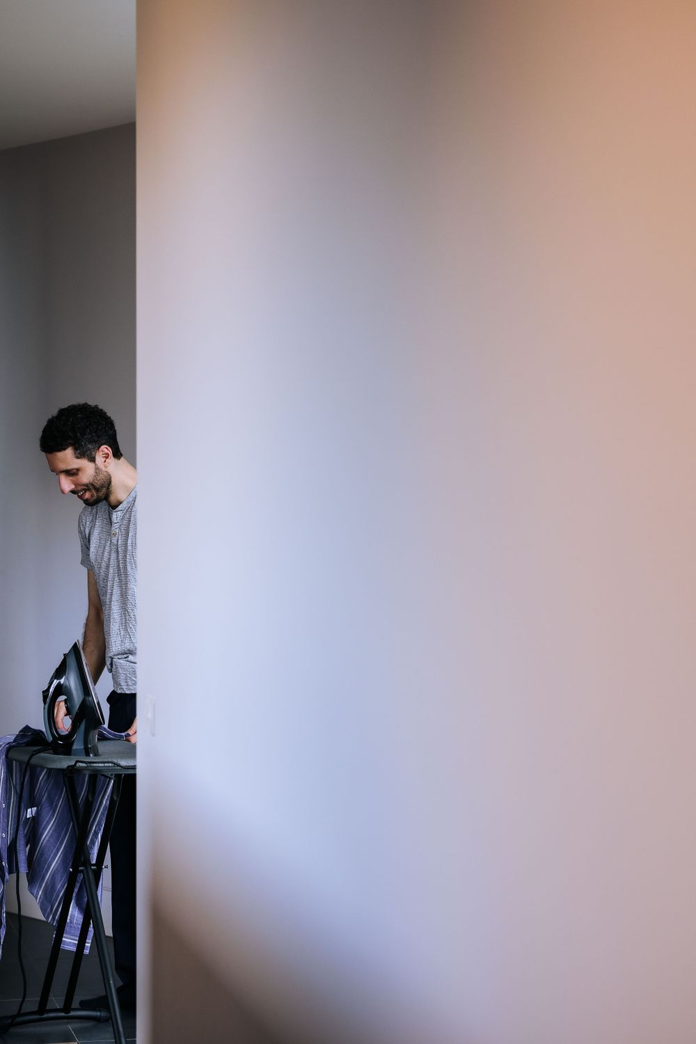 A creative composition showing someone partially visible through a doorway in soft lighting.