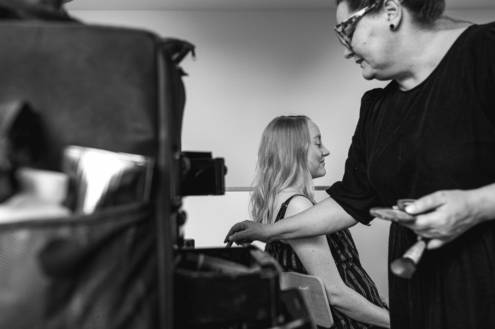 A black and white behind-the-scenes moment during a photography session.