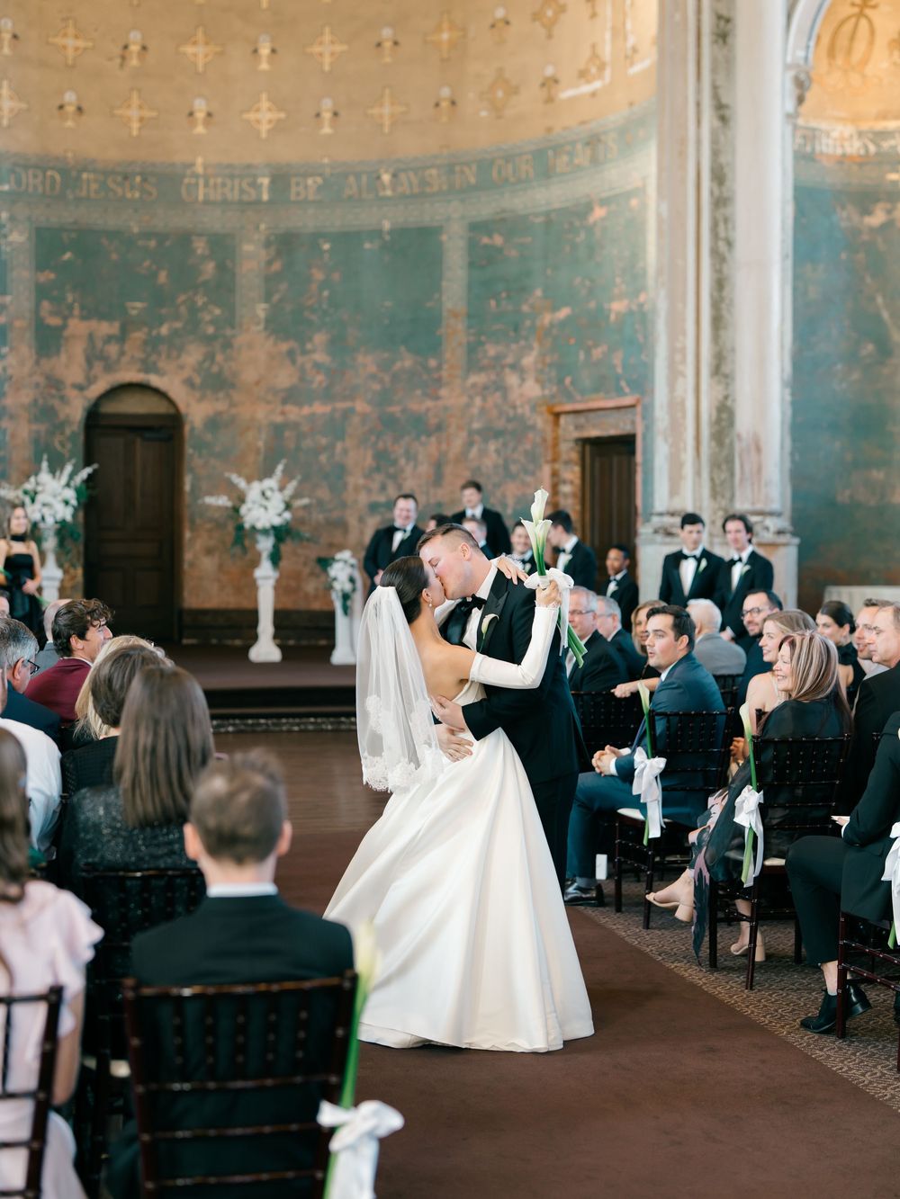 A series of candid wedding moments showing celebratory dances and joyful movement in an elegant ballroom with blue walls.