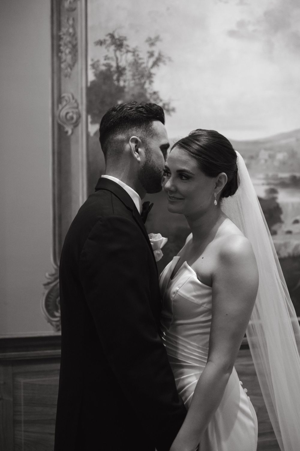 Intimate black and white wedding portrait showing the couple in a close embrace.
