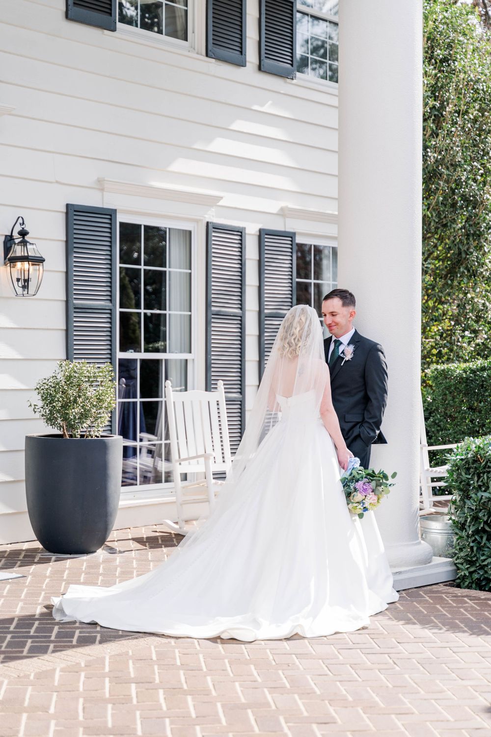Elegant wedding portrait against white colonial house with black shutters. The Highgrove Estate, Fuquay-Varina, NC