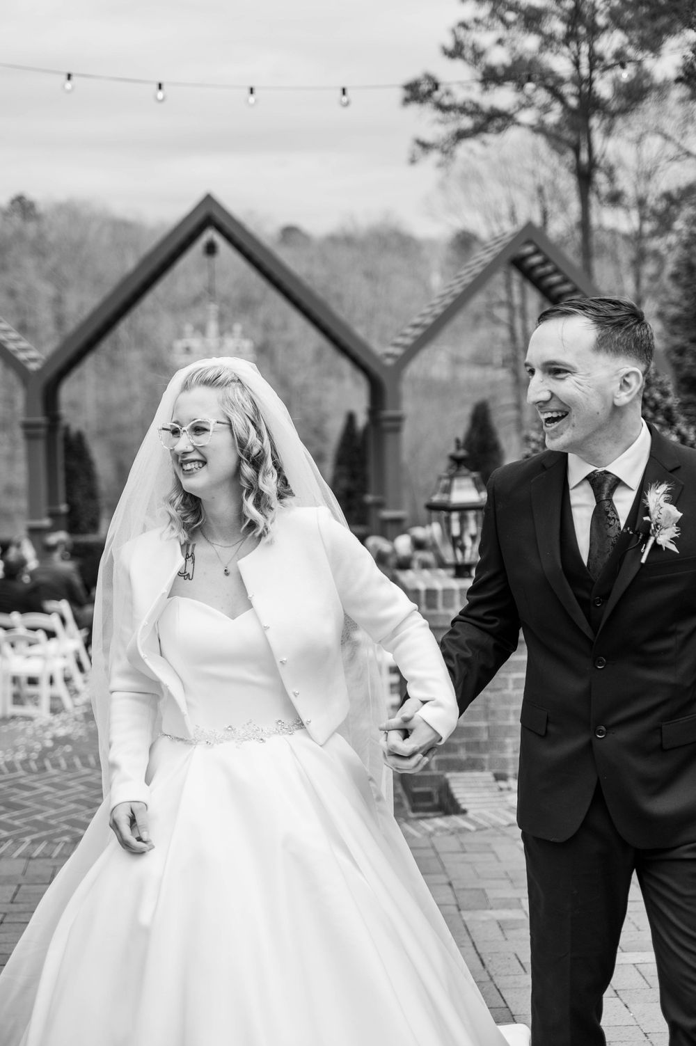 Black and white photo of newlyweds sharing a joyful moment outdoors. The Highgrove Estate, Fuquay-Varina, NC