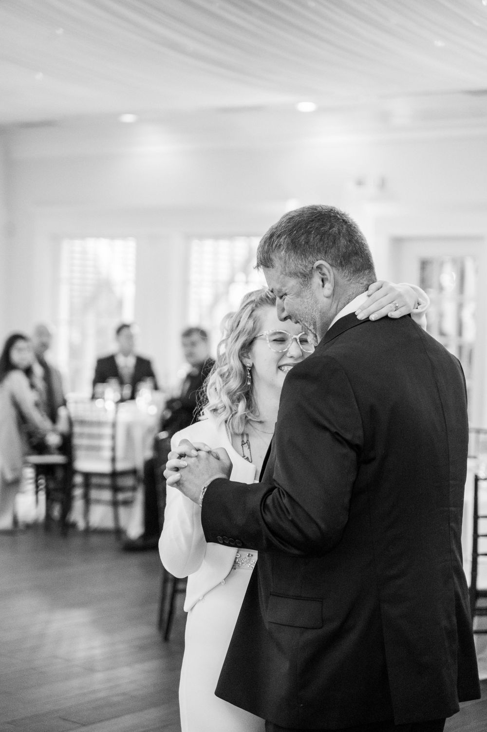A tender first dance moment between newlyweds in formal attire at their wedding reception.