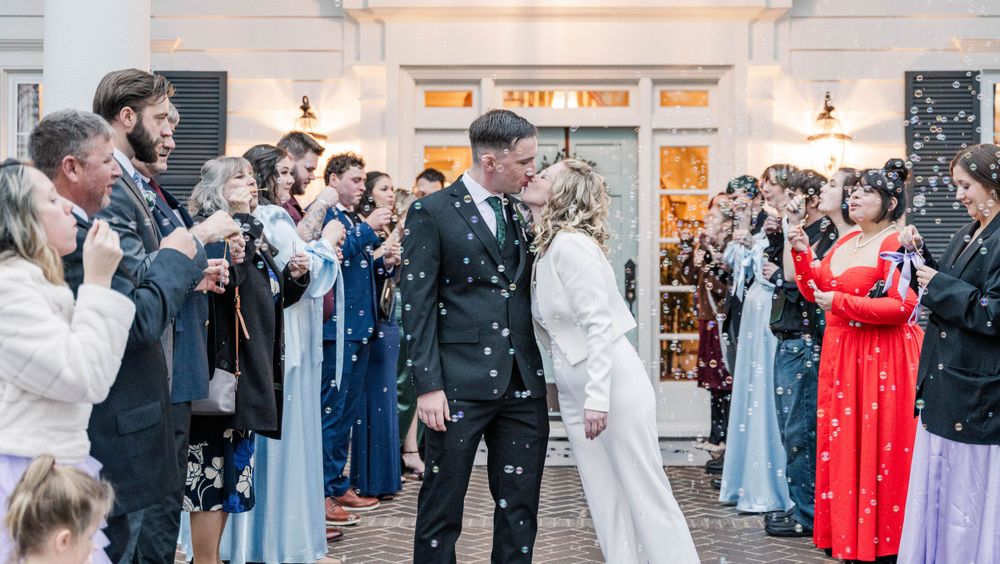 Wedding guests throw confetti as newlyweds exit their ceremony venue.