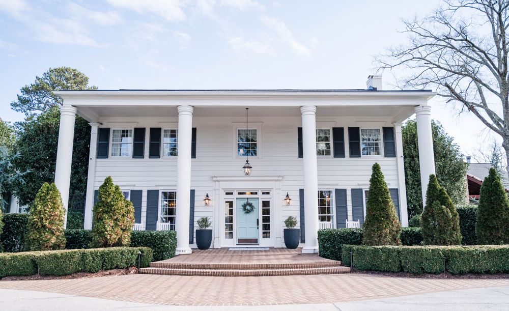 A grand white Southern mansion with tall columns and manicured landscaping. The Highgrove Estate, Fuquay-Varina, NC