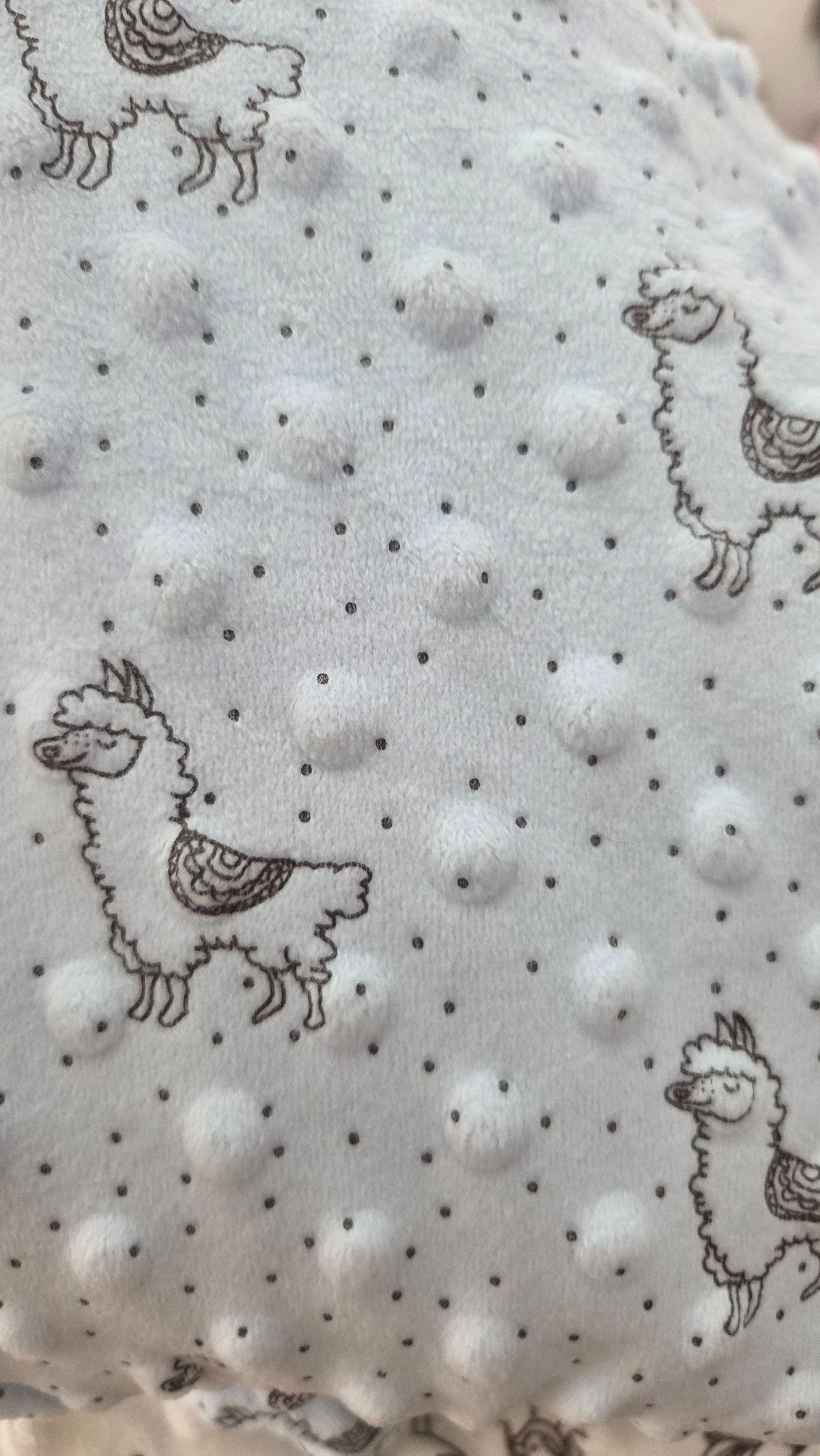 Light blue minky dot fabric featuring cute llama illustrations with small polka dots, showcasing soft raised bubble texture.