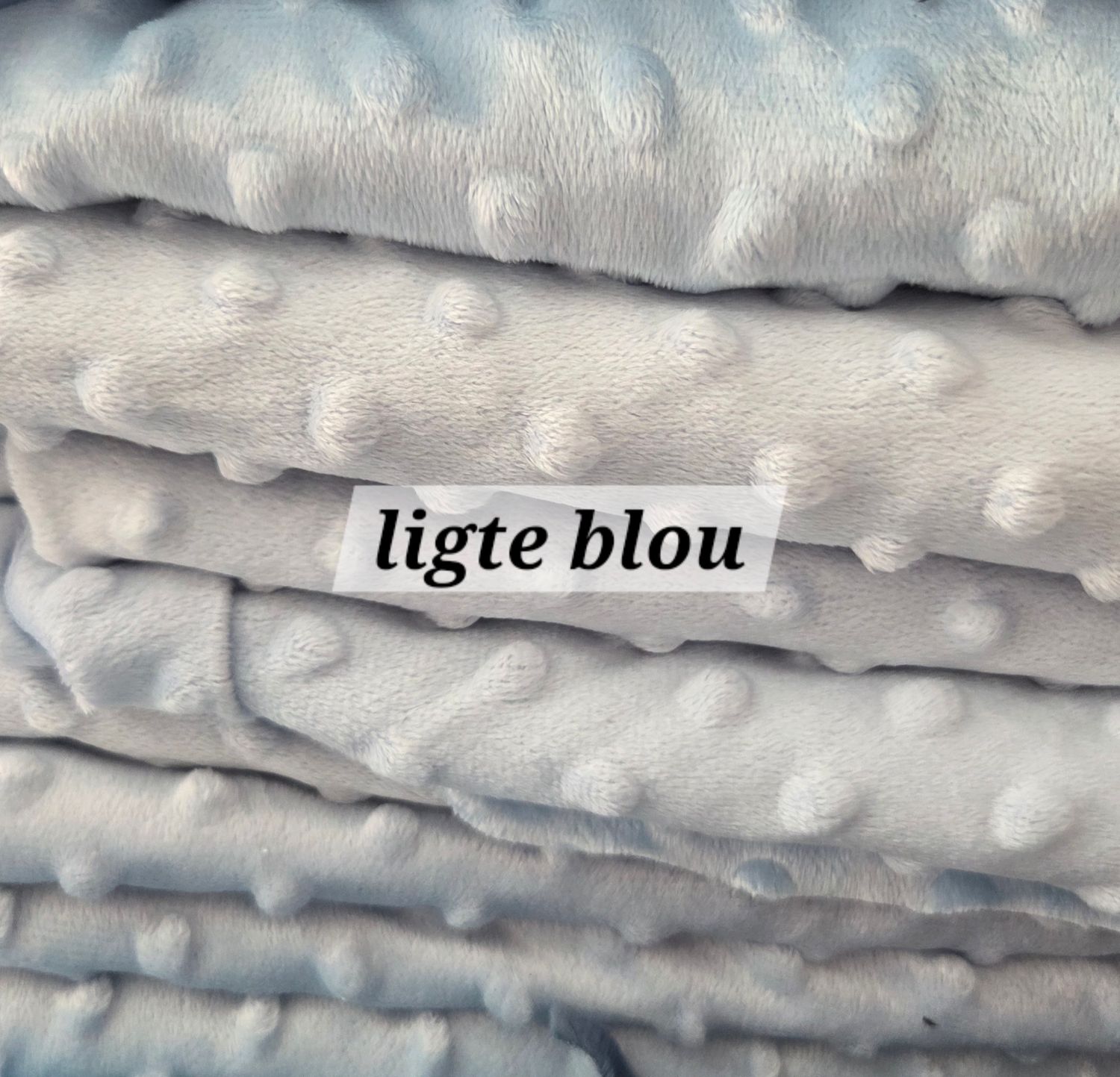 Stacked light blue minky dot fabric with raised polka dot texture, labeled ligte blou, soft plush baby blanket material.