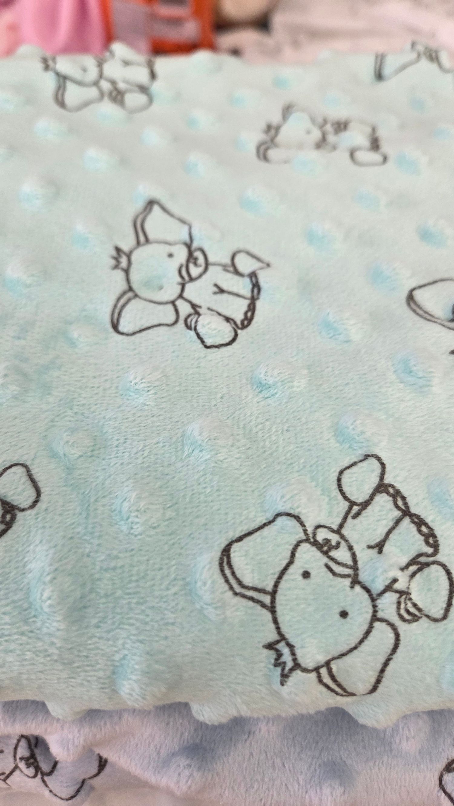 Soft blue minky dot baby blanket with cute elephant print pattern, perfect for newborns.