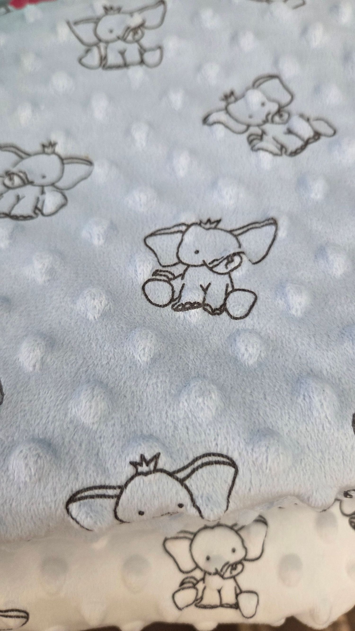 Soft blue minky baby blanket featuring adorable gray elephant print pattern with raised polka dot texture.