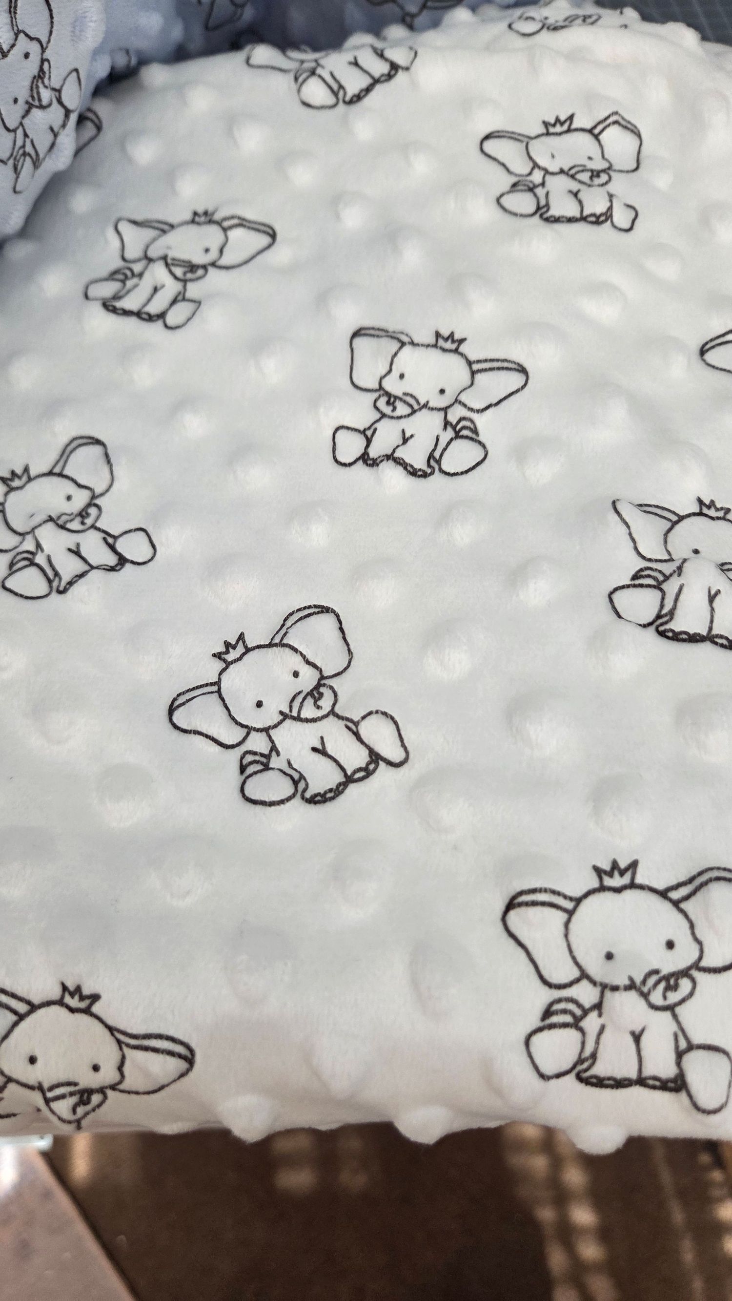 White minky dot fabric featuring cute black and white elephant print pattern, perfect for baby blankets and nursery items.