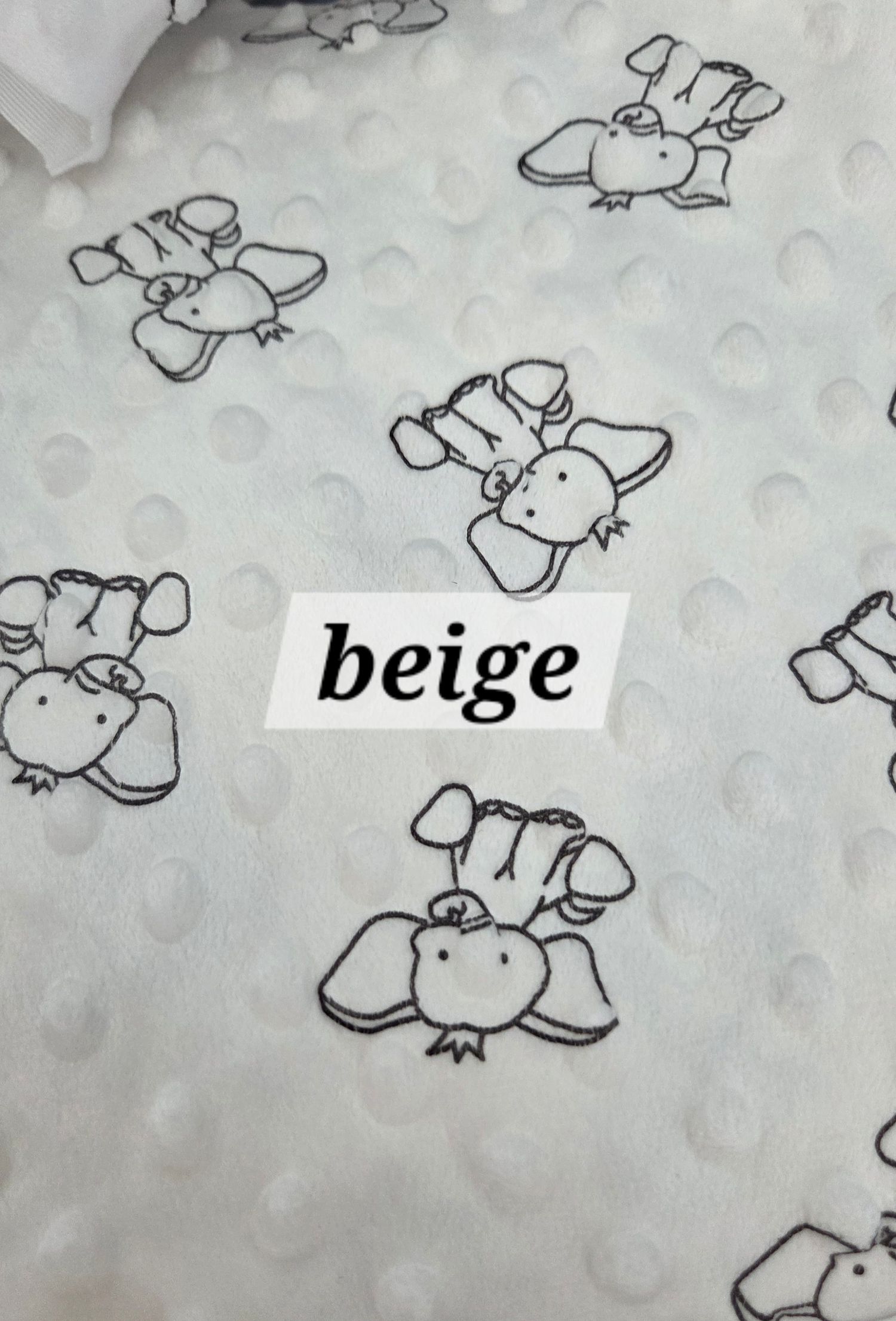 Beige minky dot fabric with black and white elephant print pattern, soft textured baby blanket material.