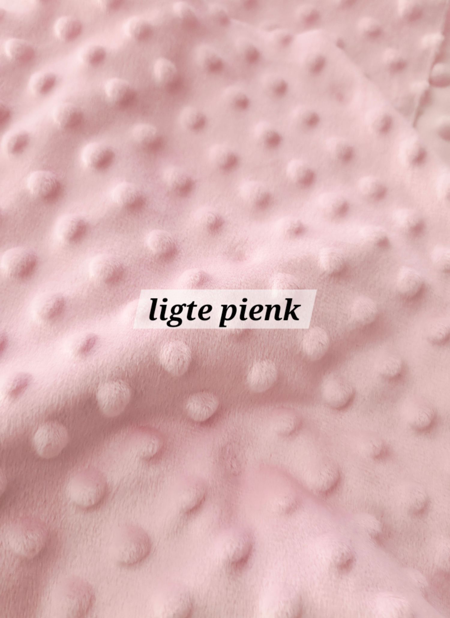Close-up of soft light pink minky dot fabric with raised polka dot texture, labeled ligte pienk.