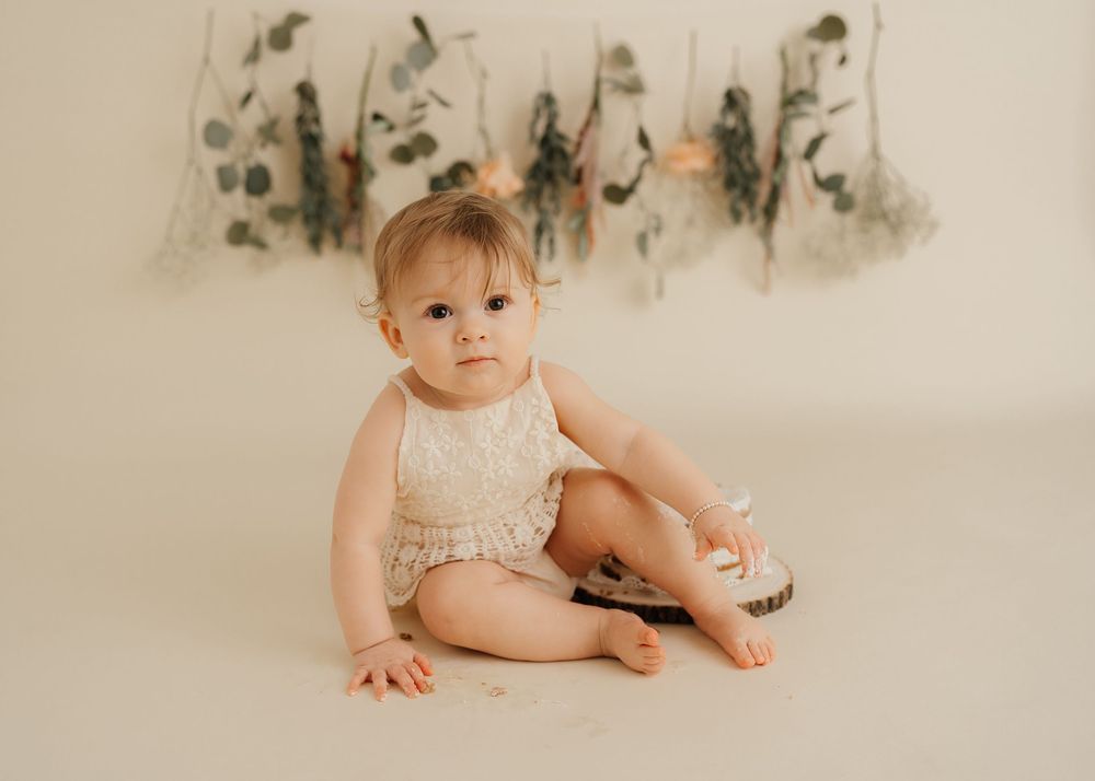 A collection of soft, neutral-toned baby photos arranged in a horizontal filmstrip style layout.
