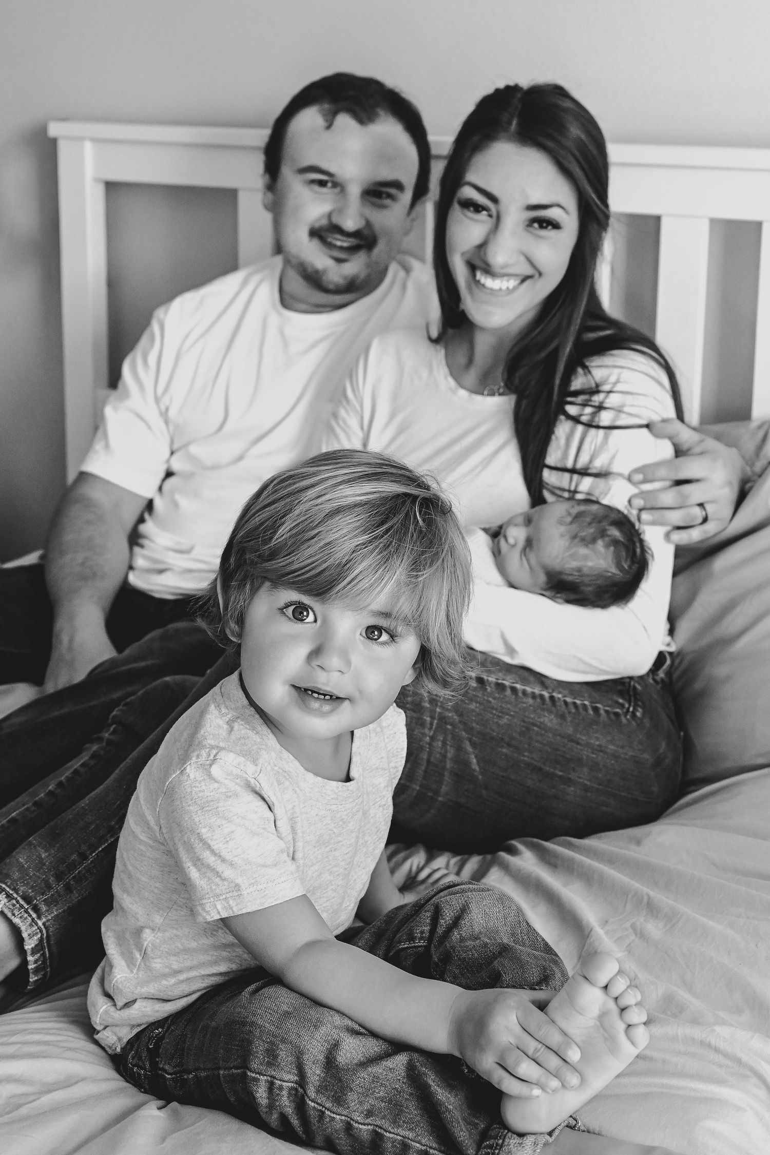 Family photo. Mom, dad, big brother and newborn baby brother in lifestyle photography session in Thornton, Colorado.