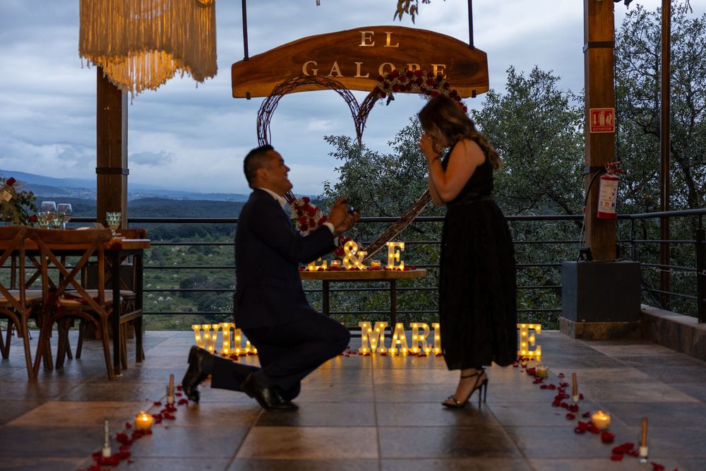 Romantic outdoor venue decorated with glowing candles and string lights at dusk.