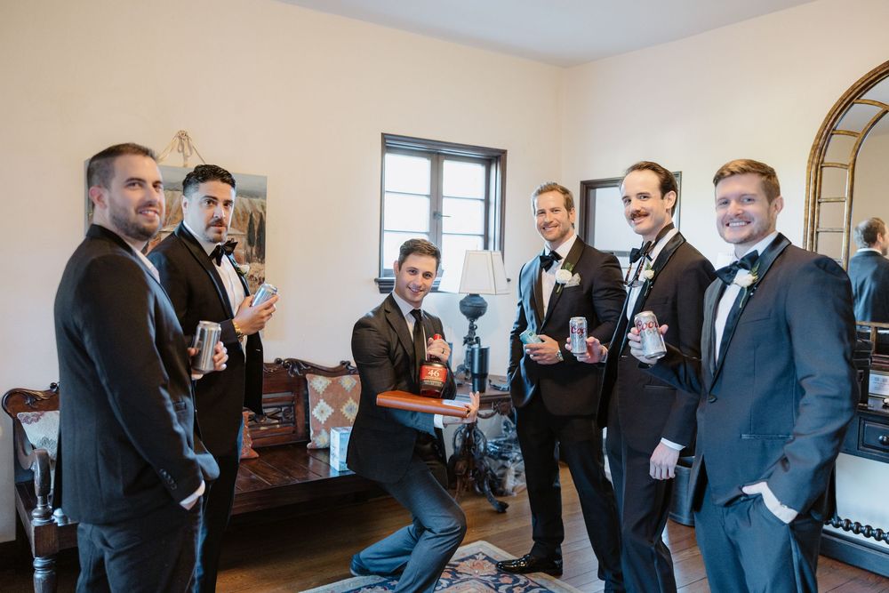 Wedding guests mingle and socialize during an indoor reception event with drinks.