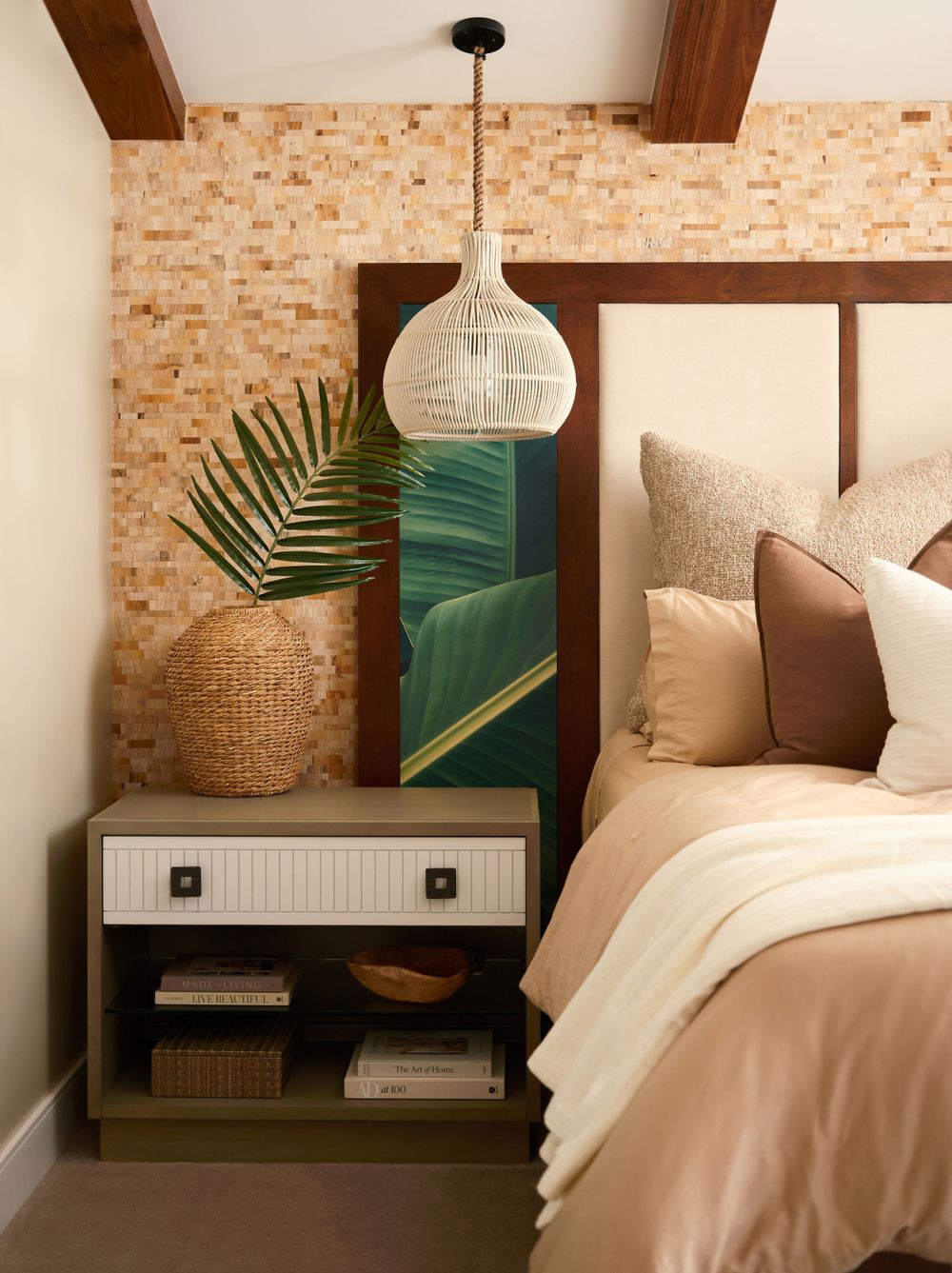 Bedroom detail with stone-textured accent wall, pendant light, and neutral tones — cozy vignette by Khoi Ly.