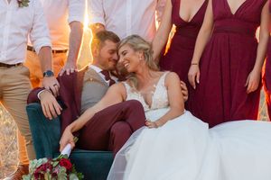 A romantic sunset moment captured at an outdoor wedding reception with burgundy decor.