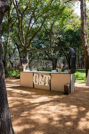 Outdoor garden terrace with stone walls and mature trees providing natural shade.