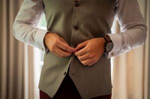 Close-up of formal attire showing grey vest and white dress shirt details.