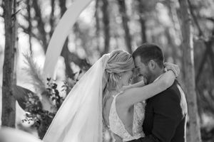 Romantic wedding ceremony moment captured in a forest setting.