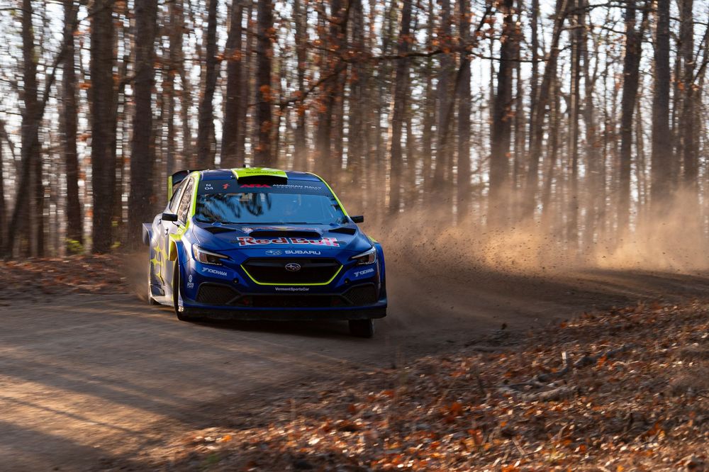 Blue performance car driving through autumn forest road.