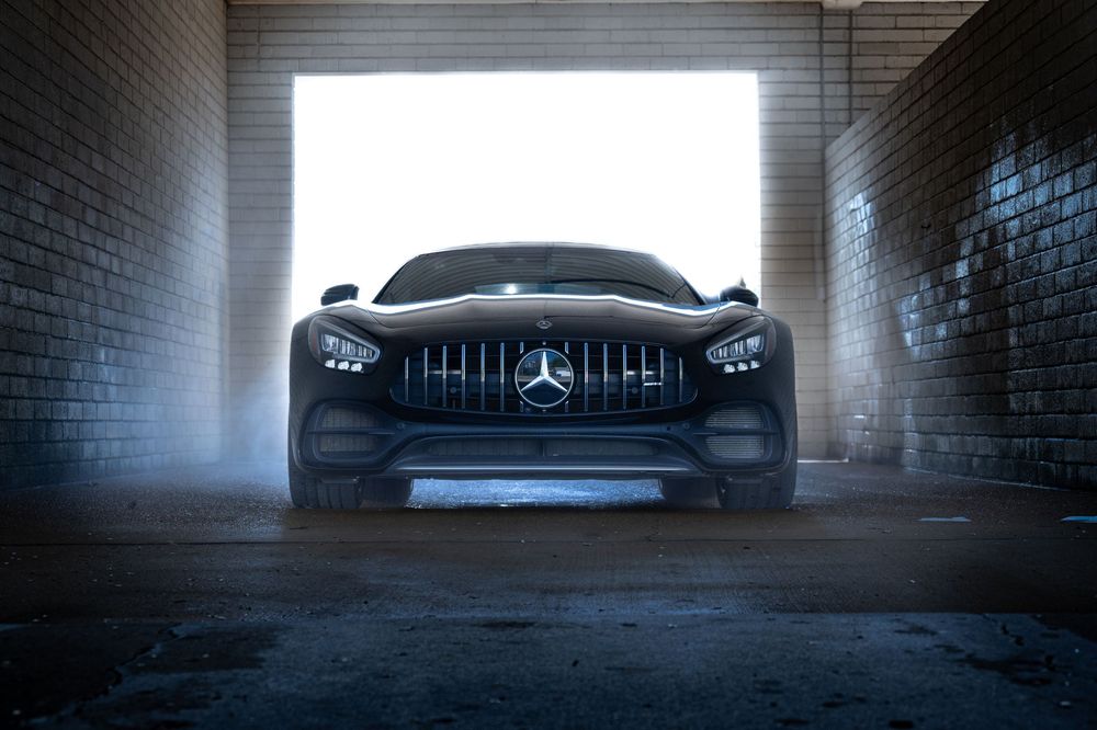 Silhouette of Mercedes AMG GT in dramatic underground parking garage.