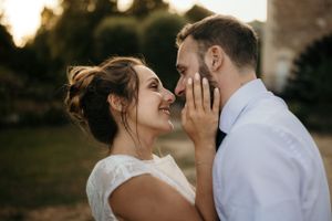 Tender moment between newlyweds sharing intimate touch at golden hour.