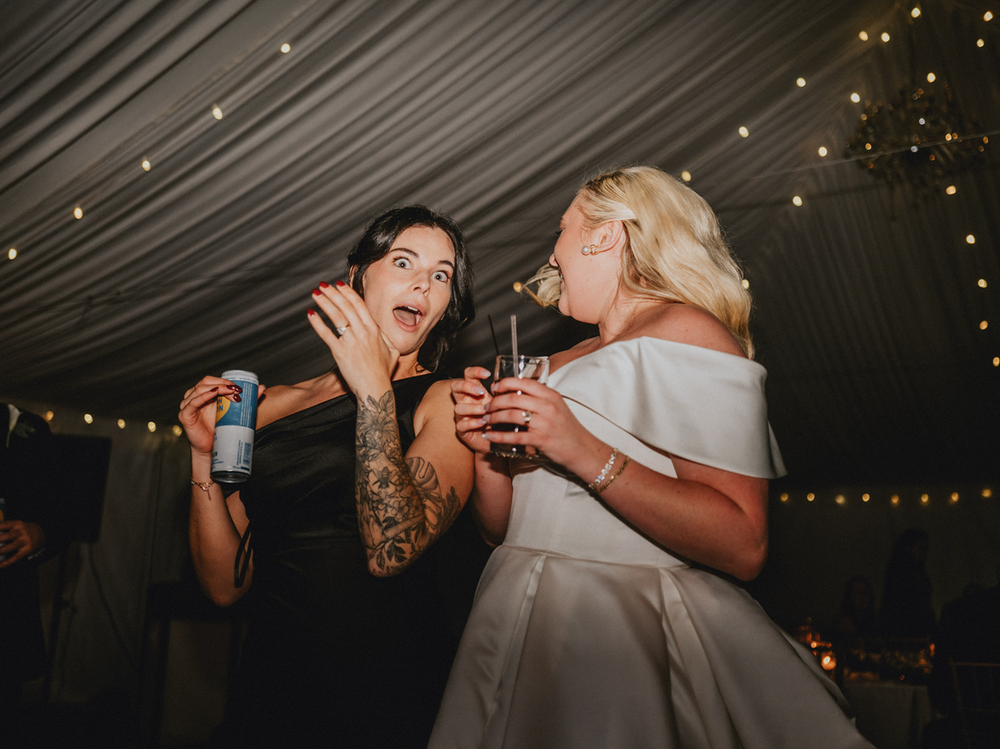 Candid reception photo of bride and best friend singing on the dance floor at Chase House, Baltimore City
