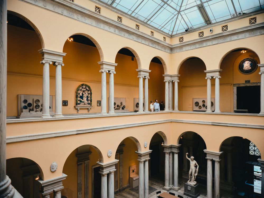 Dramatic wide-angle engagement portrait in the atrium of The Walters Art Museum in Baltimore.