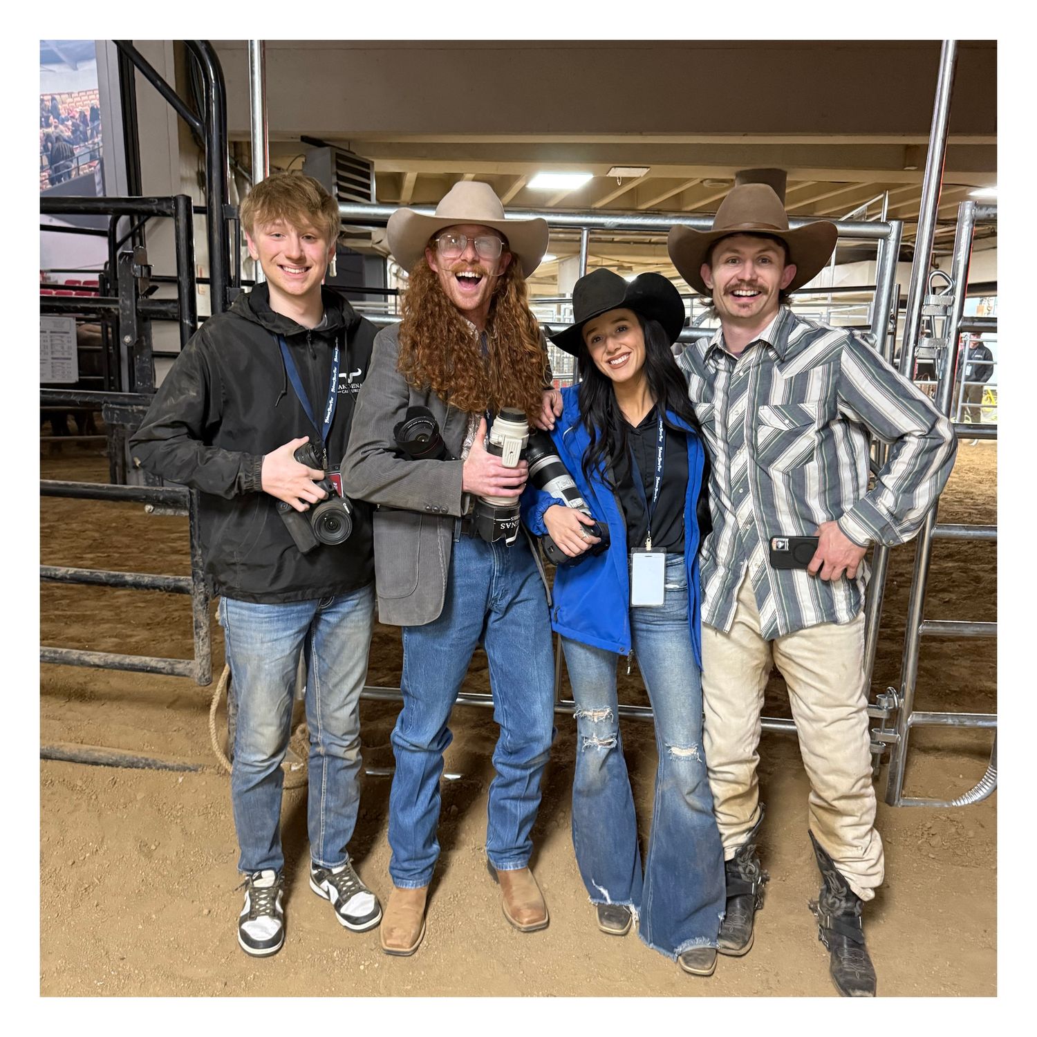 Group wearing western attire and cowboy hats poses together at a rodeo event.