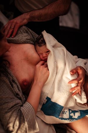 Medical treatment scene with white towel and careful hand positioning.