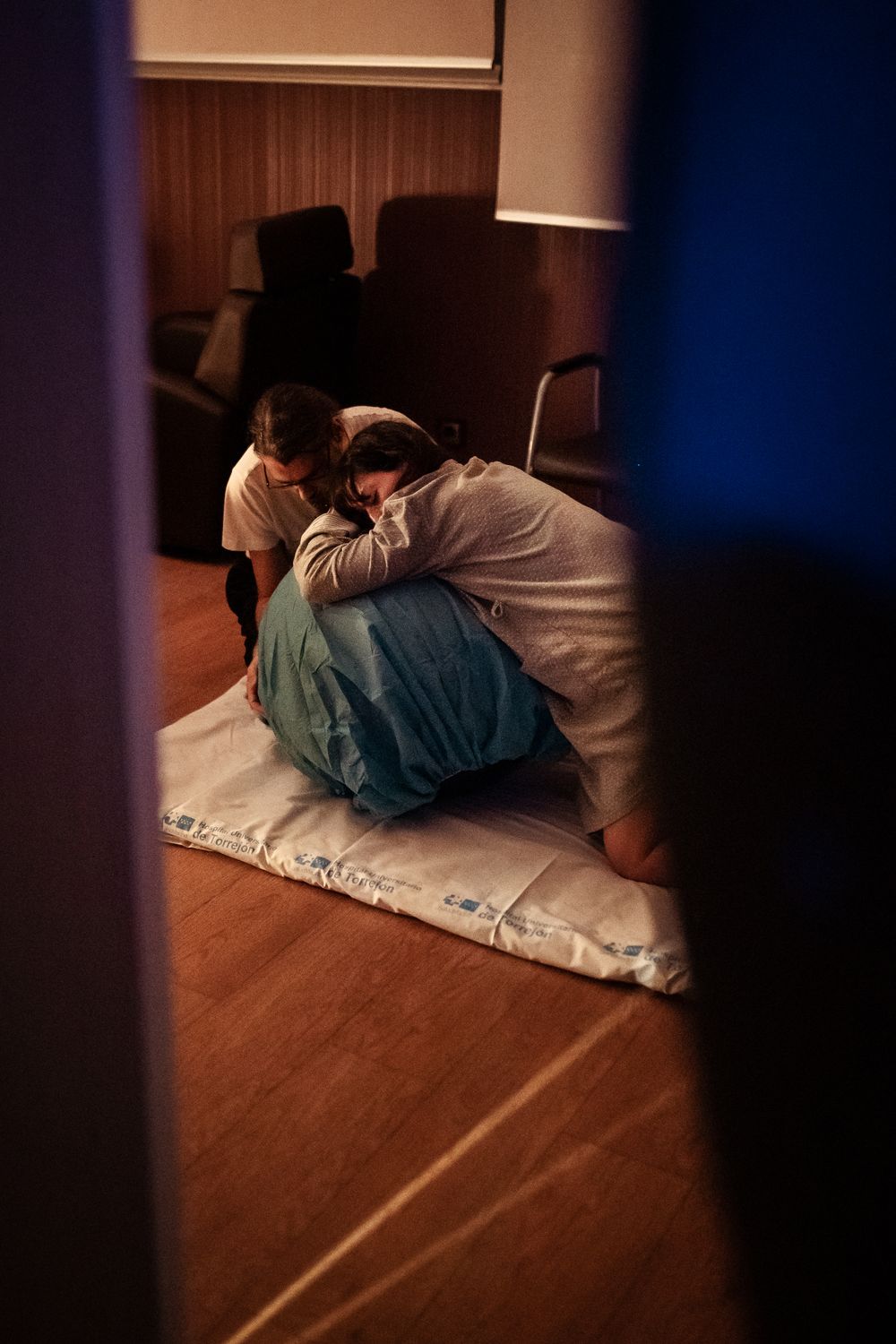 Low-light images showing a birthing scene on a hospital floor.