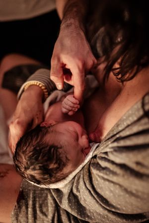 Close-up view of hands providing medical care in dim lighting.