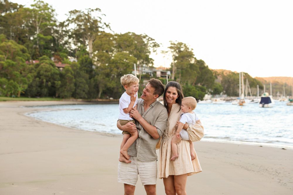 beautiful stunning family photo taken at the beach at golden hour. featuring Mum dad and two boys